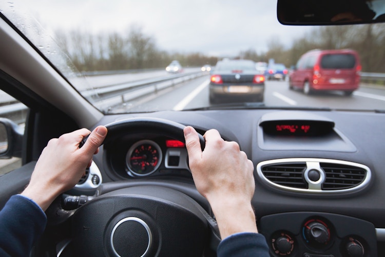 A person driving a car in traffic. 