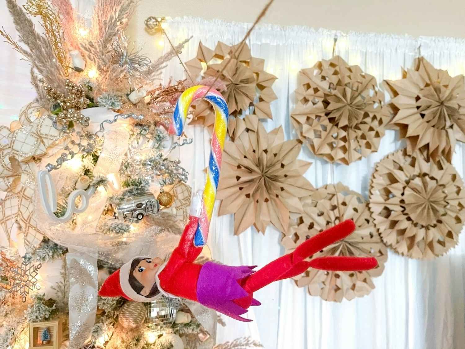 elf on the shelf riding candy cane zipline through living room