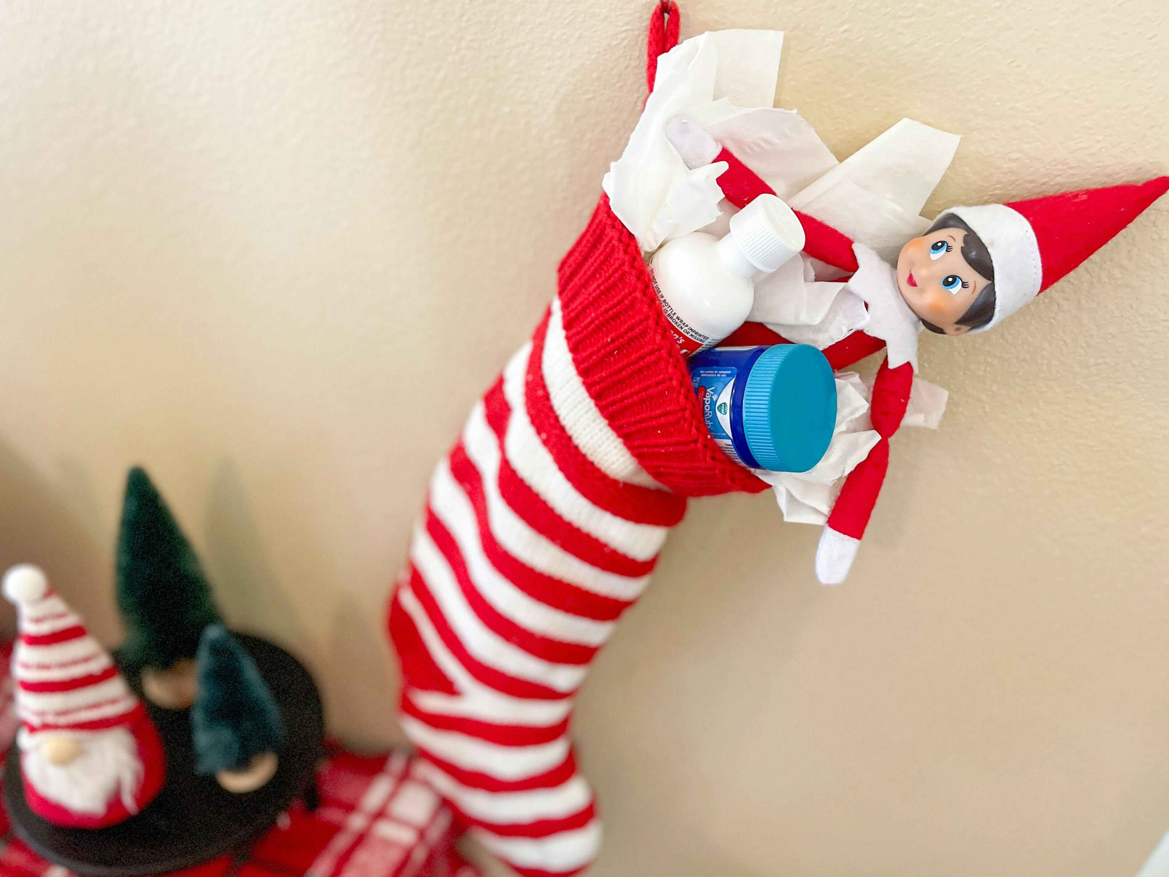 elf on the shelf doll in a stocking with tissues and cold medicine 