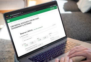 Someone applying the Enterprise military discount to their car rental form