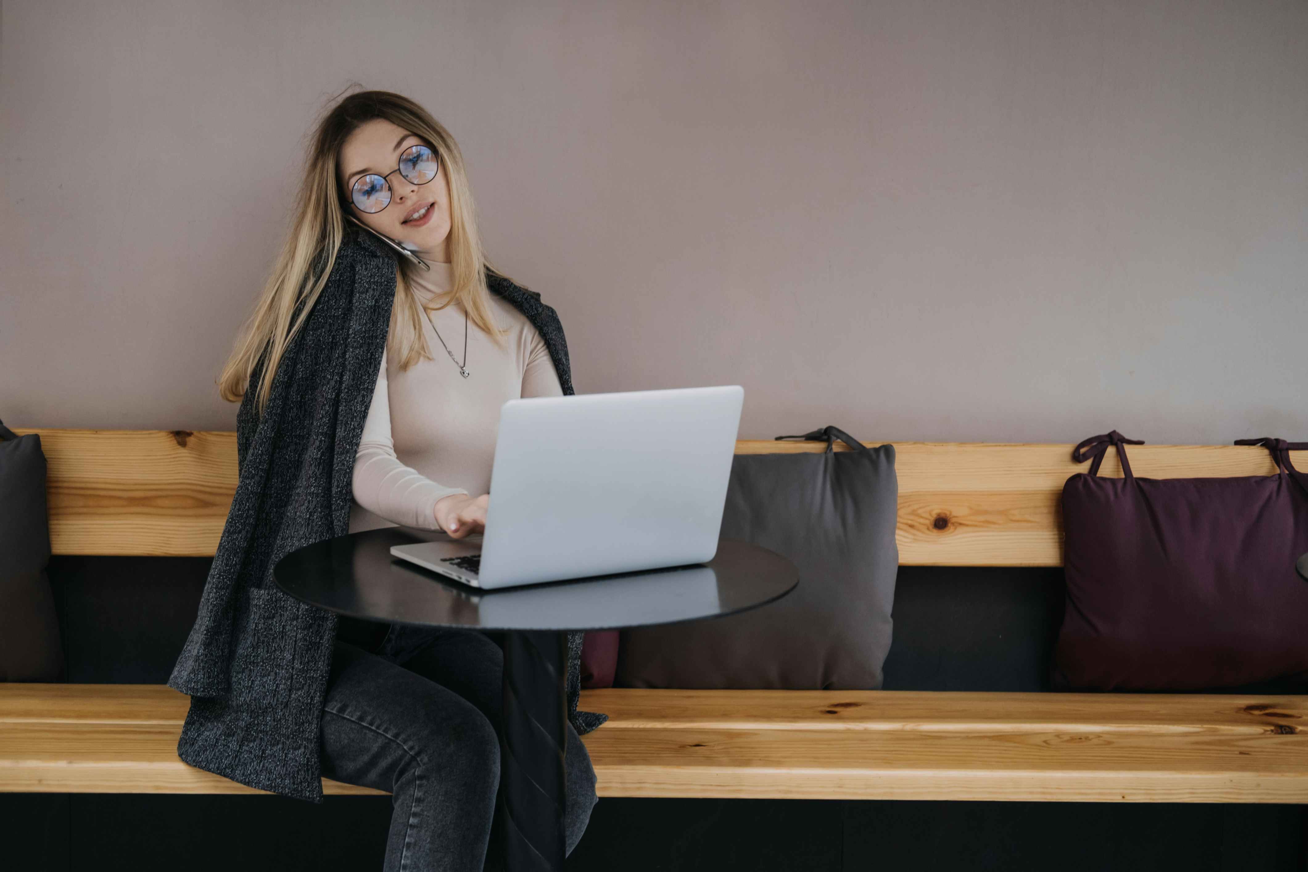 Gig woman working on laptop and talking on the phone