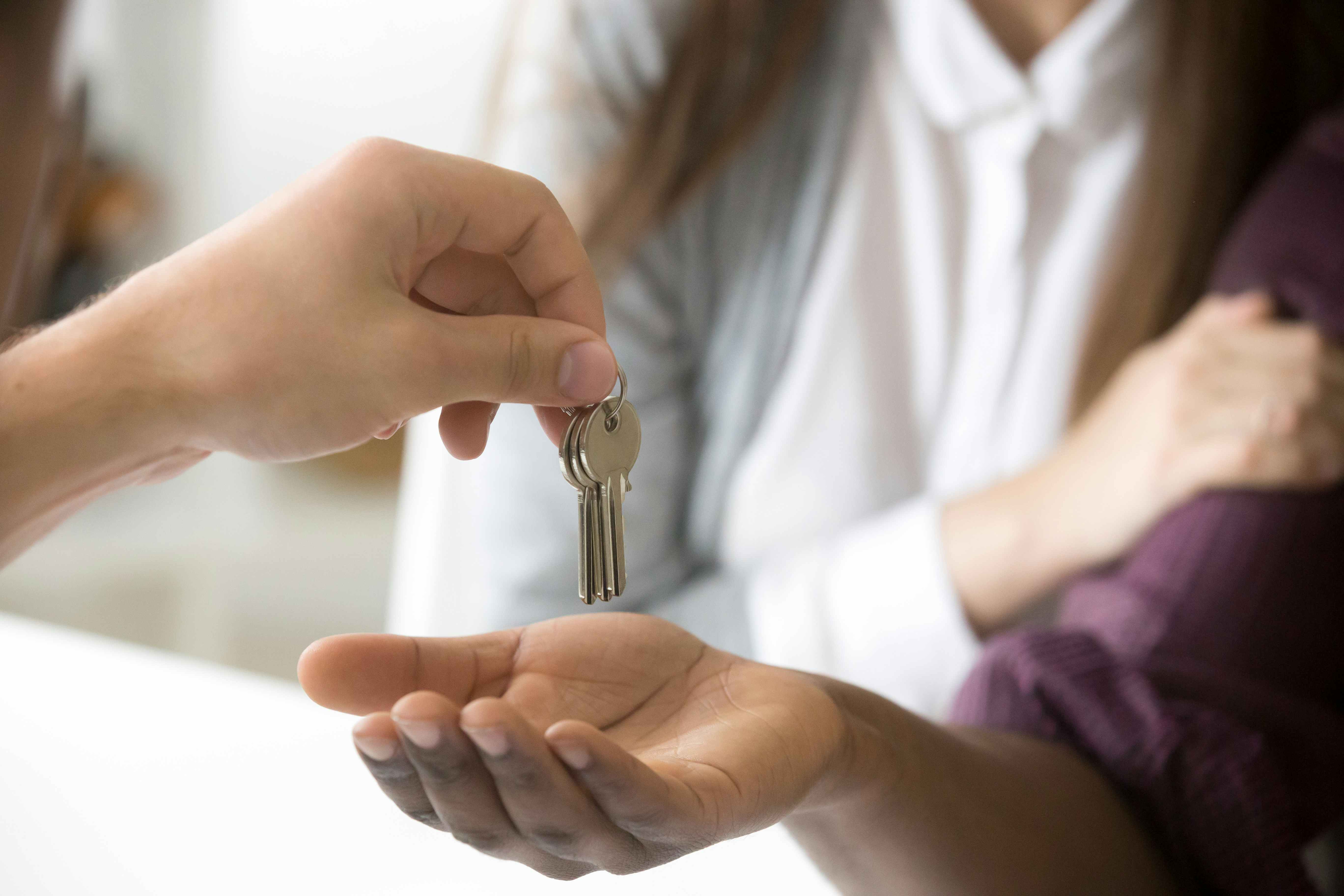 Person giving house keys to another