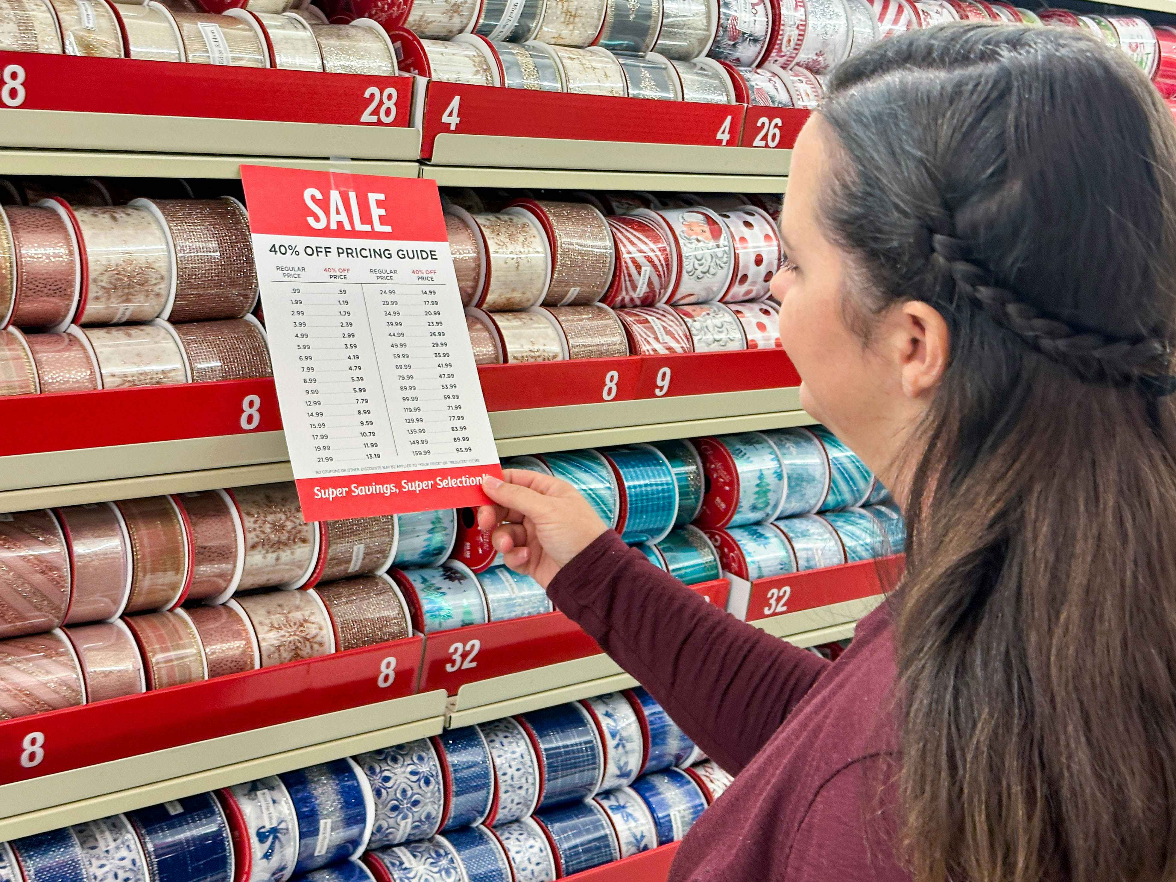 a woman looking at sale pricing in the chrsitmas ribbon section
