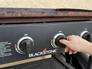 Someone turning on a Blackstone griddle