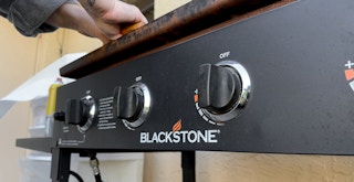 Someone cleaning a Blackstone griddle