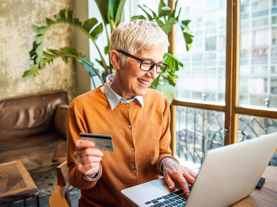 Older woman shopping online with her credit card