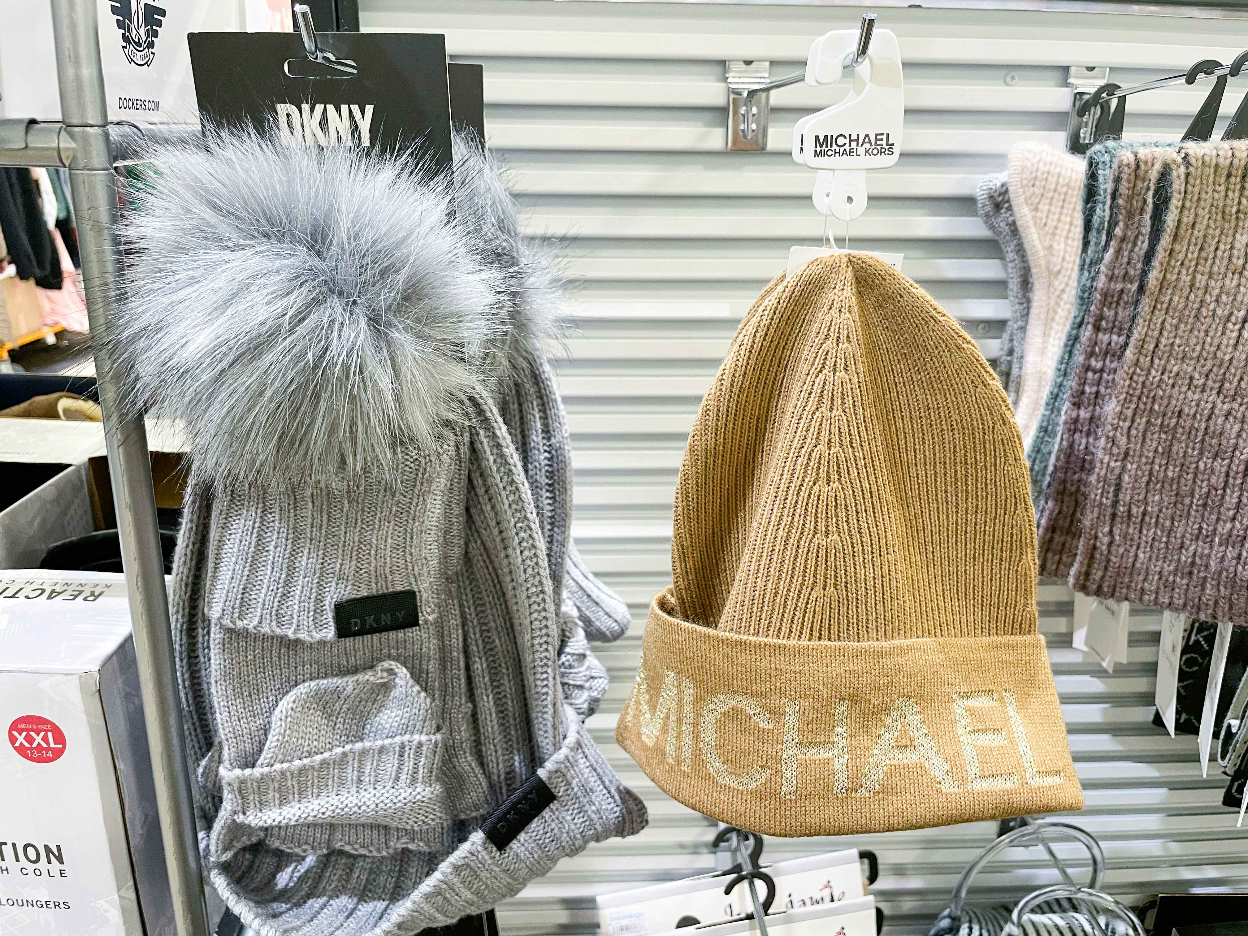 a michael kors beanie and a DKNY hat and glove set hanging next to each other at Macy's Backstage