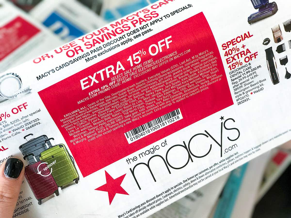 Someone holding up a coupon for Macy's