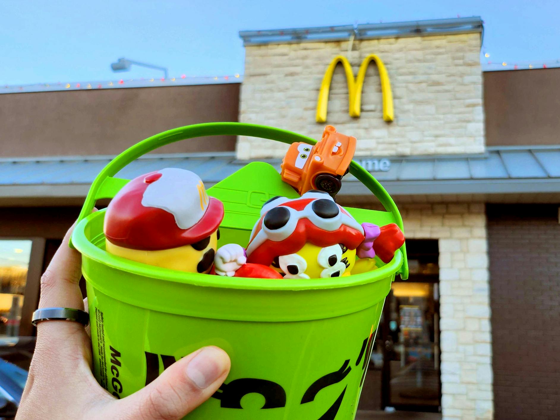 mcdonalds halloween bucket with four mcdonalds toys inside set before a mcdonalds