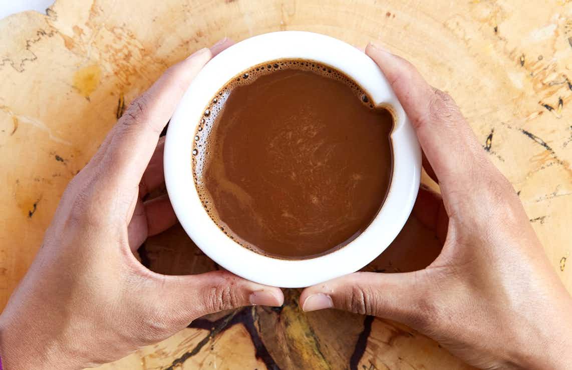 two hands holding a cup of cocoa from vosges