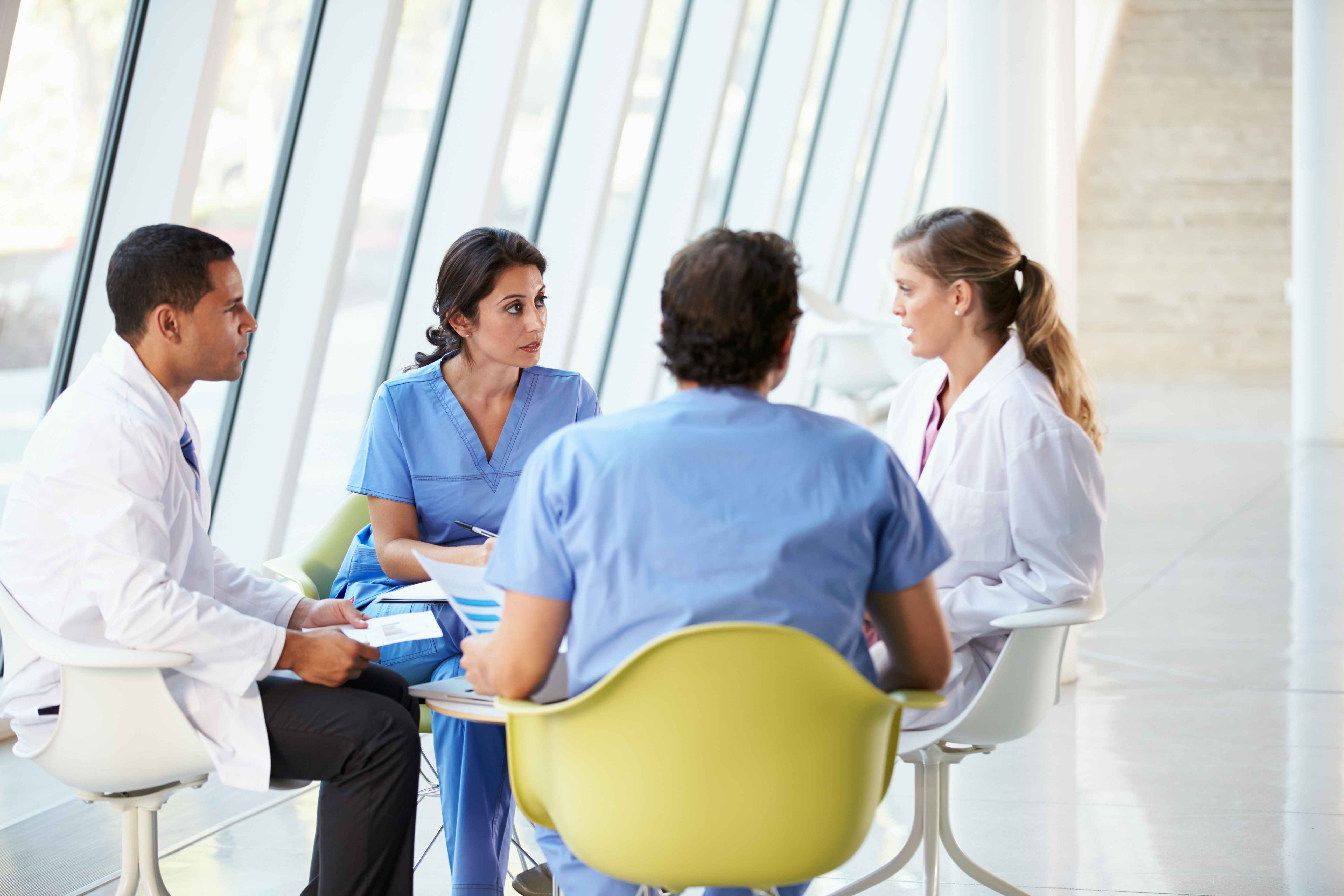Group of medical professionals seated at a table together having a conversation