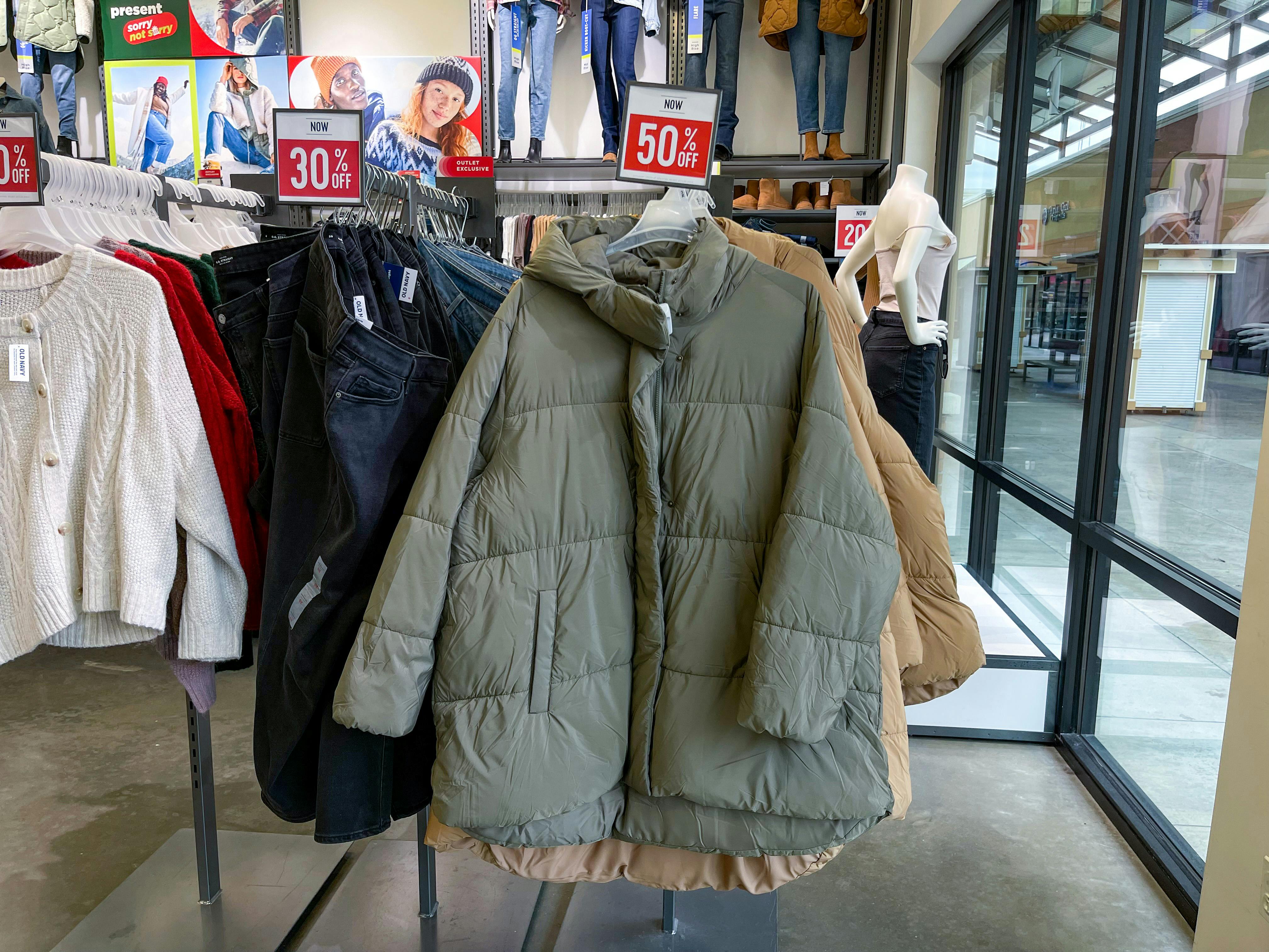 A big puffer jacket hanging on a store rack with a 50% off sign