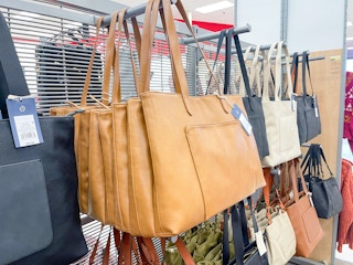 A variety of purses hanging on a store rack.