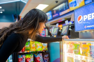Woman looking at candy by the concessions stand inside Regal Cinemas