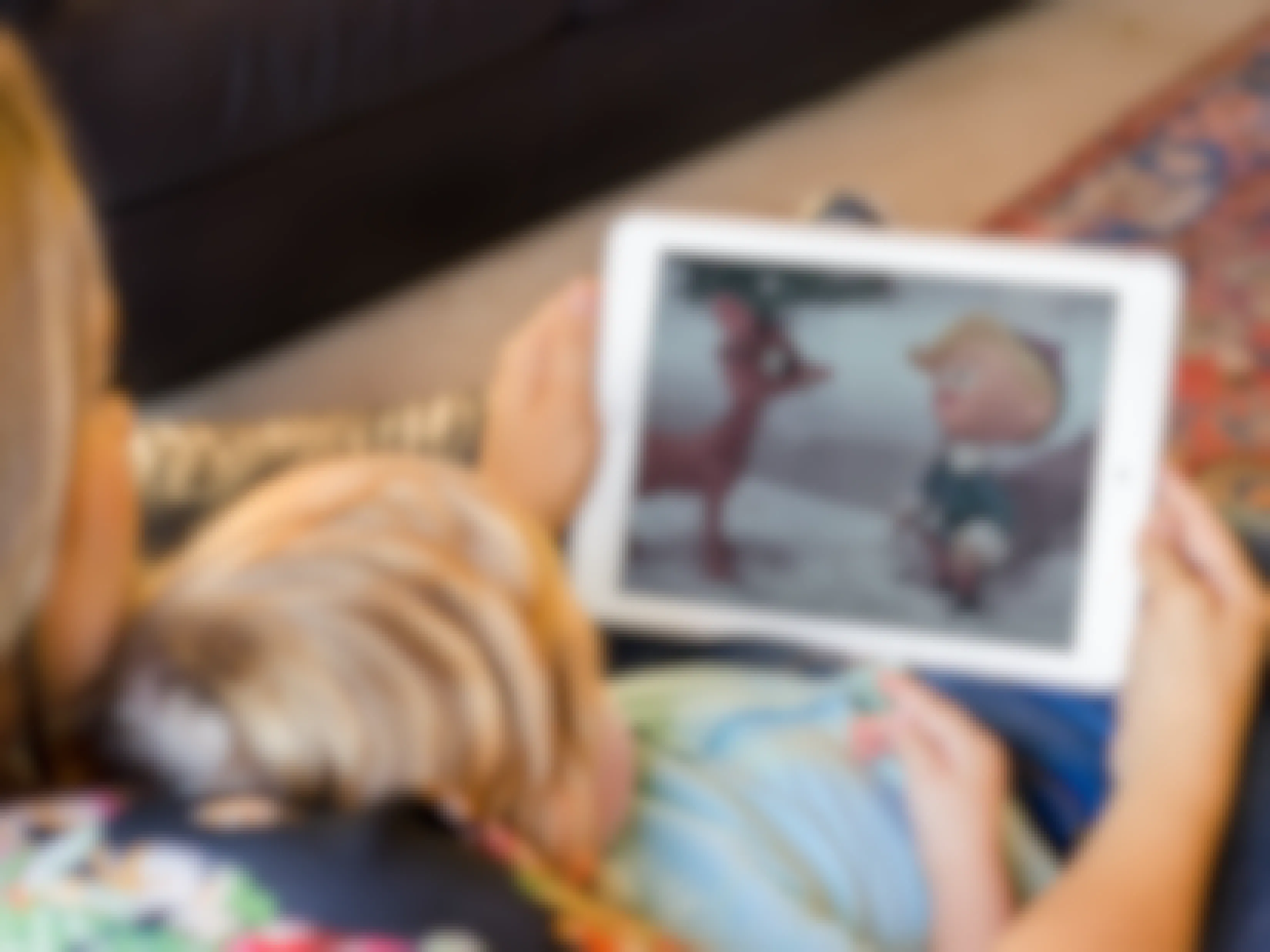 Mom and kid watch Rudolph the Red Nosed Reindeer on an iPad