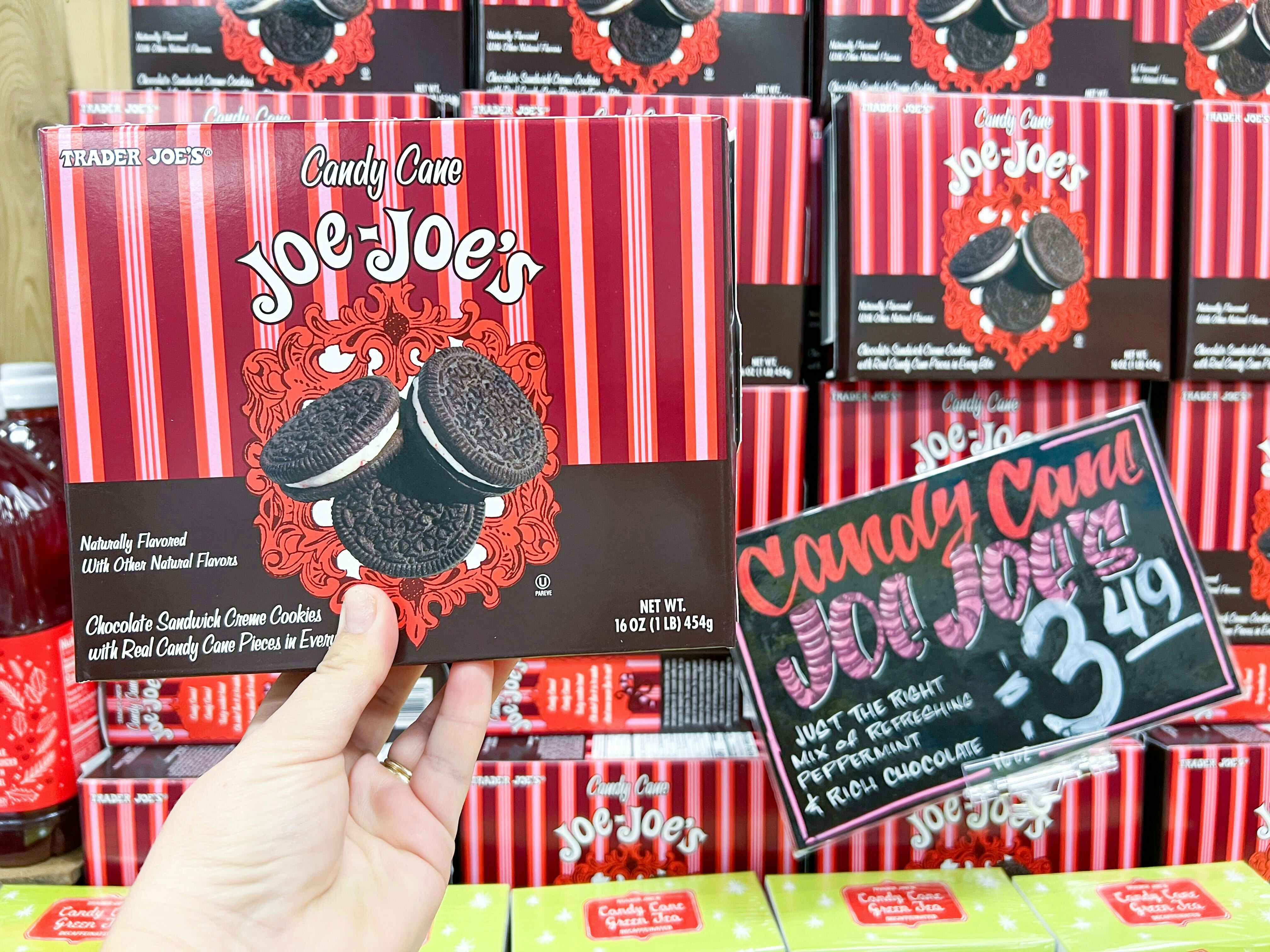 hand holding a box of Trader Joe's Candy Cane Joe-Joe's in front of display with sale price in front