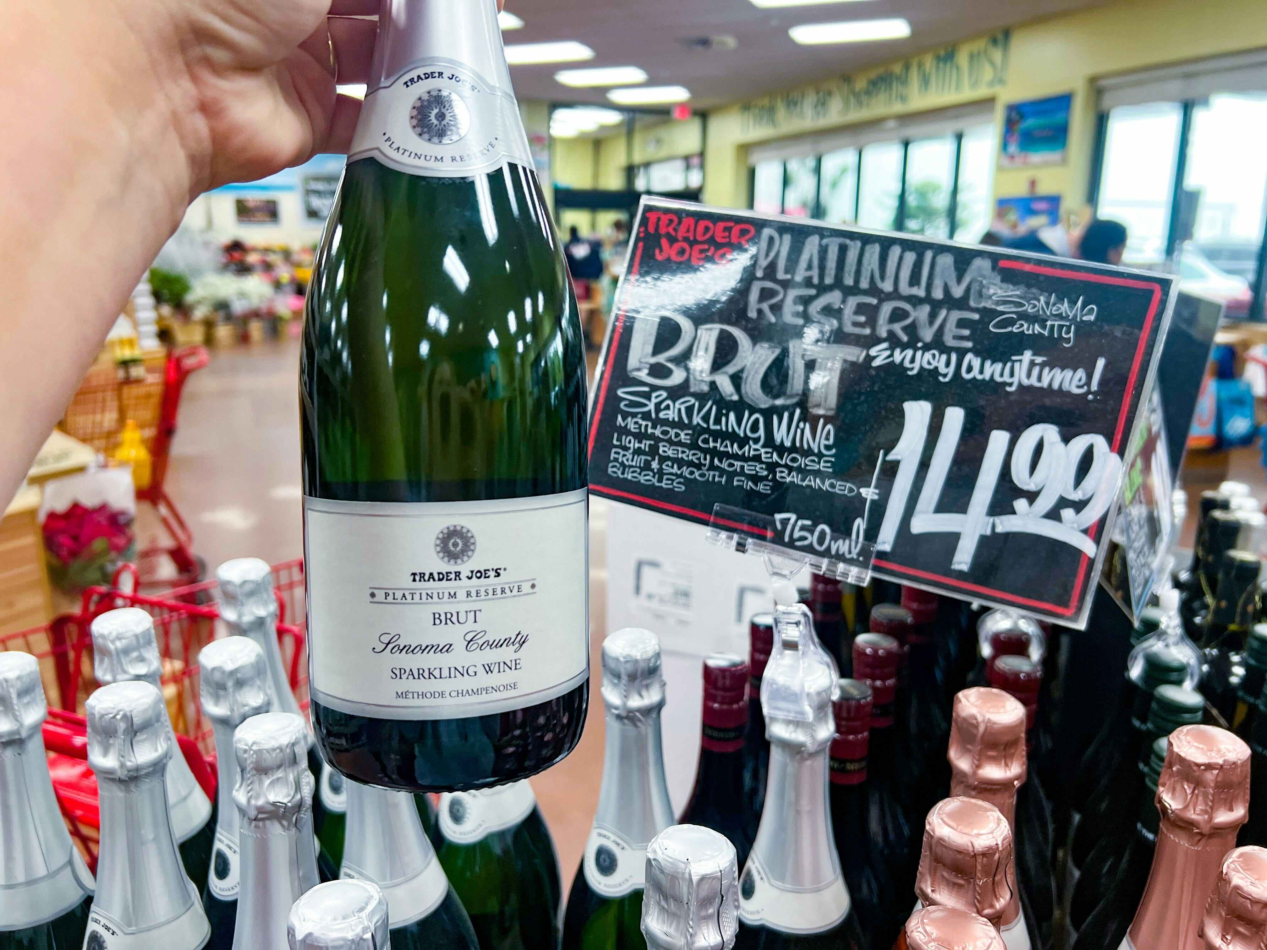 bottle of Trader Joe's Platinum Reserve Sonoma County Brut being held up in front of sign