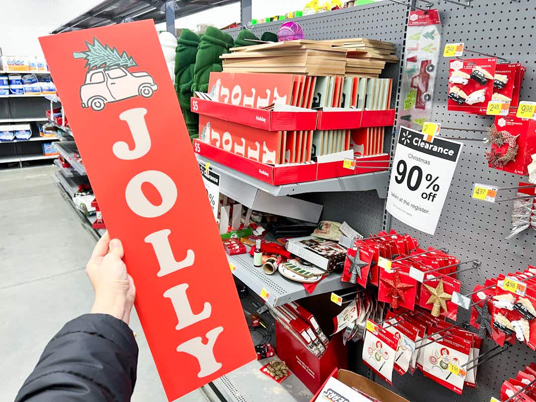 a person holding a christmas sign in the clearance area 
