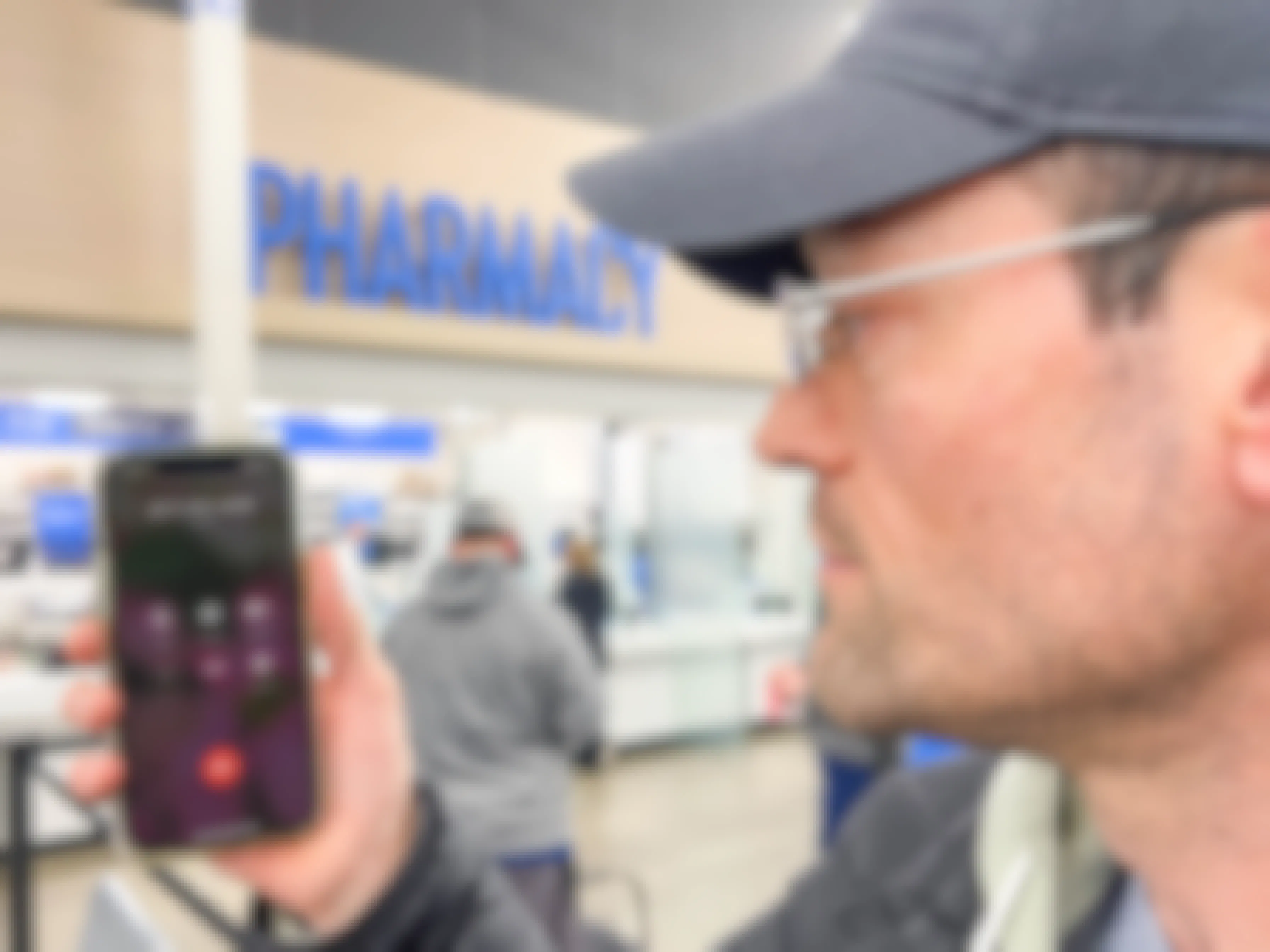 a man holding a phone calling a number in front of the walmart pharmacy 