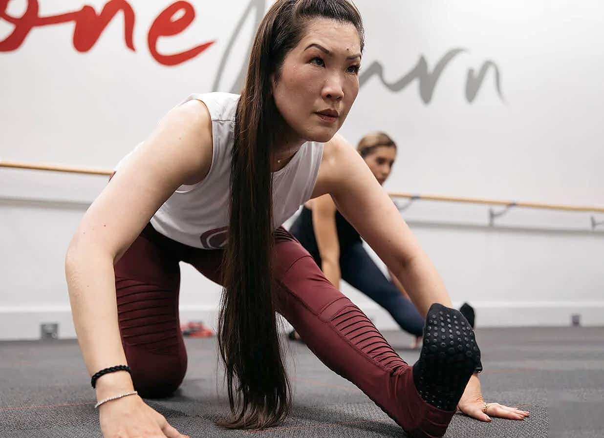 person doing hamstring stretch at pure barre location