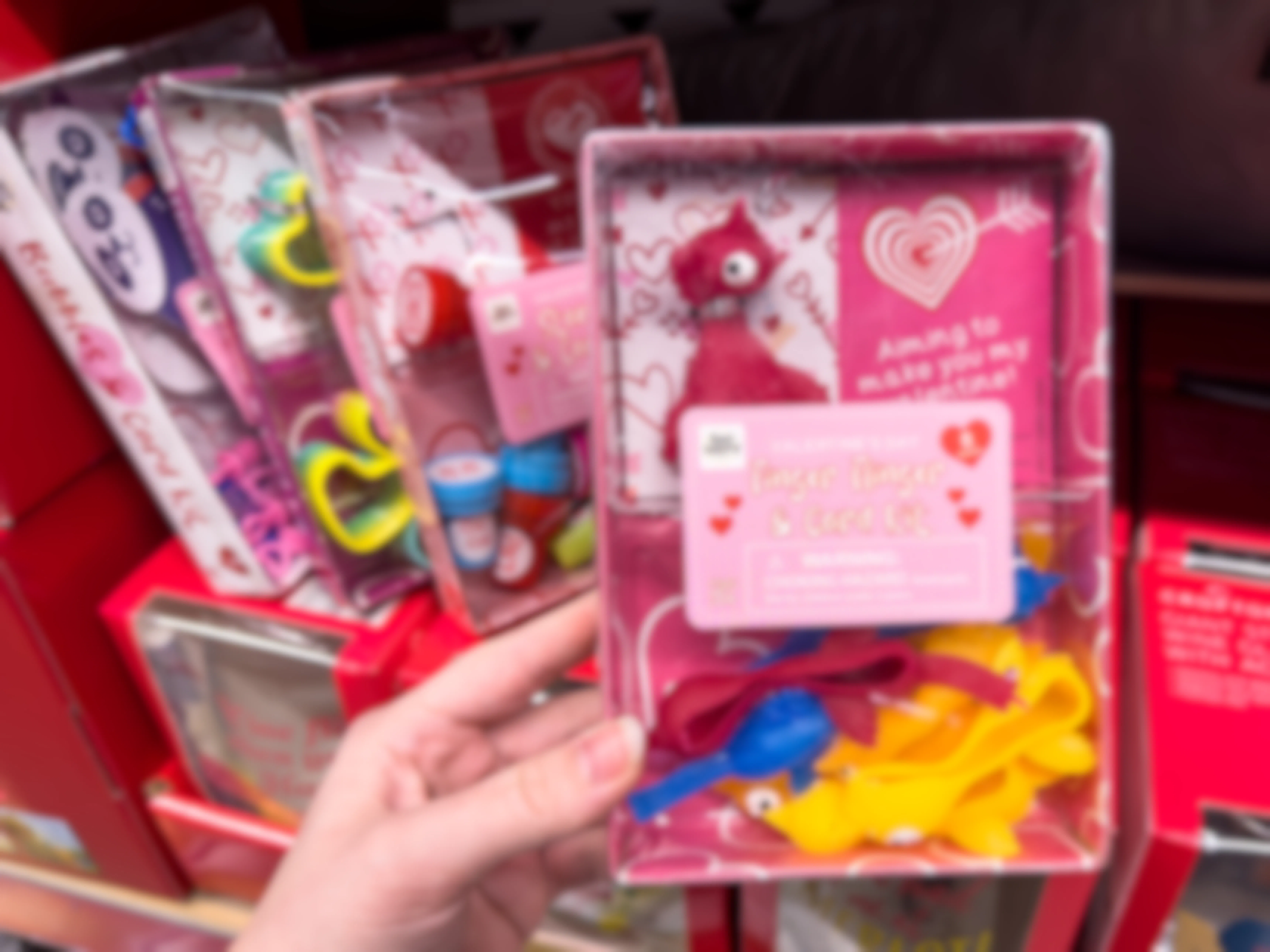 Someone holding a finger flingers and card Valentine's Day kit at Aldi