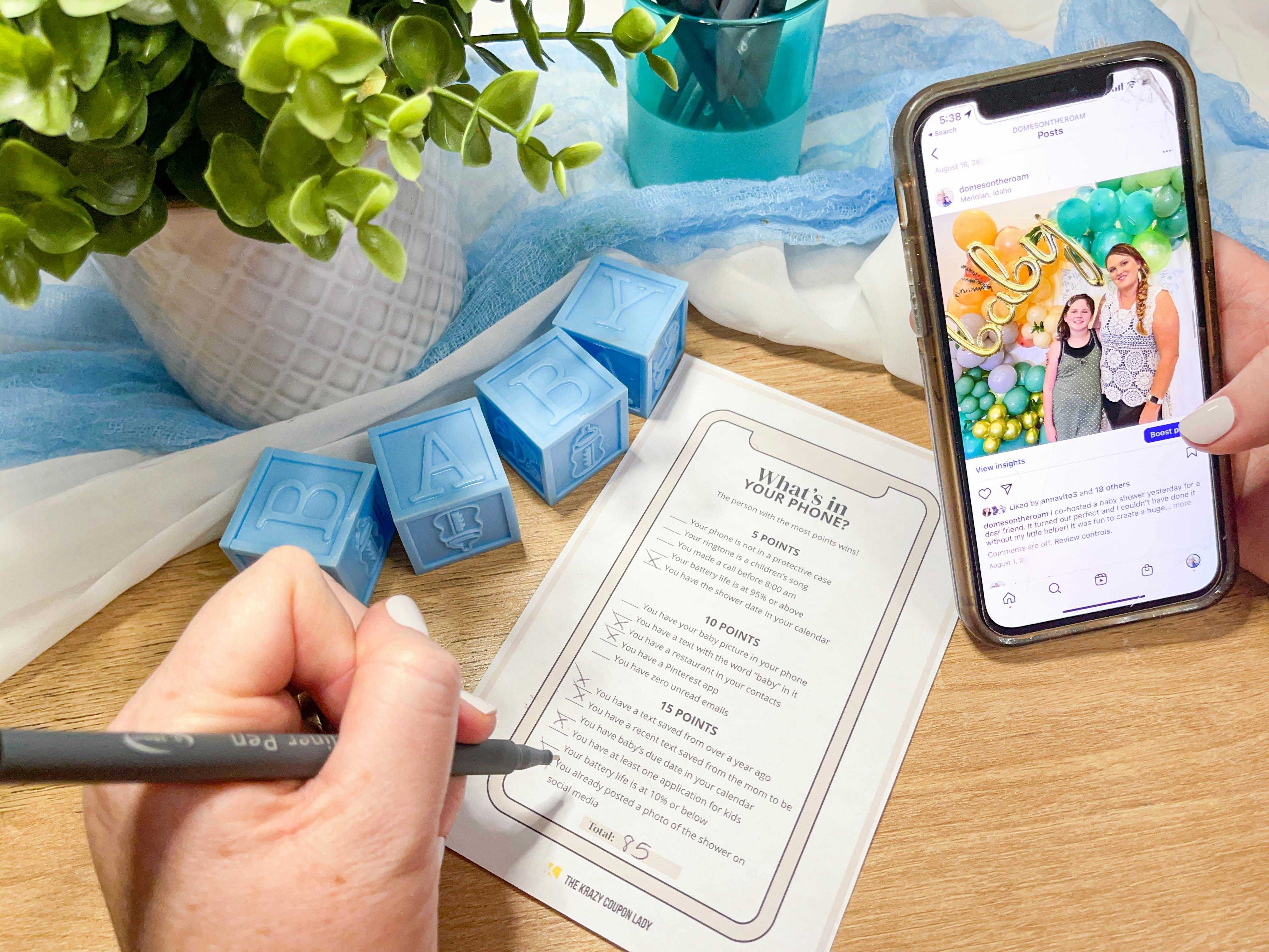 baby shower game with a person filling out and holding a phone with social media on the screen 