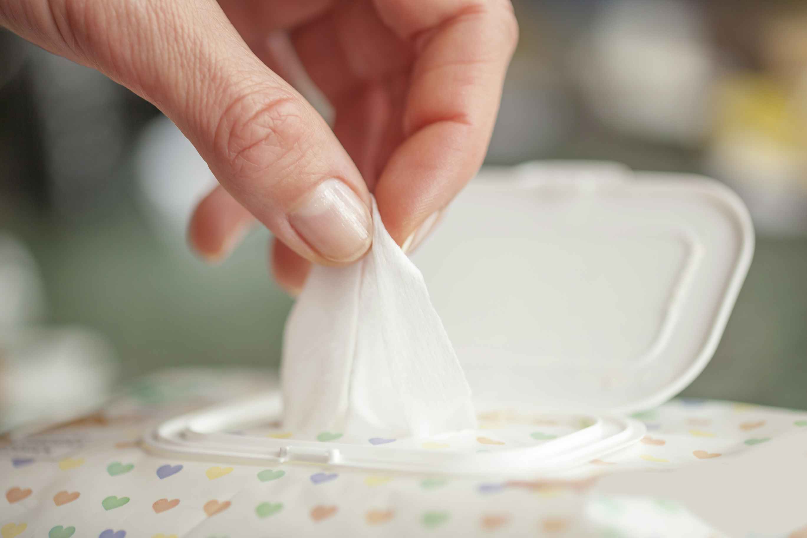 Hand pulling baby wipes out container