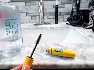 Person holding mascara wand 