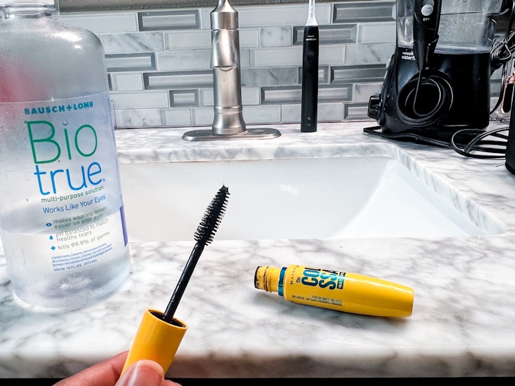 Person holding mascara wand