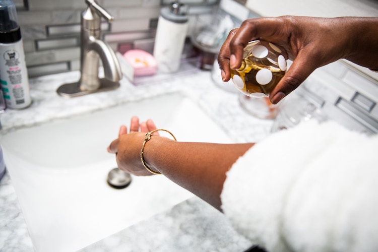 Person applying perfume to arm