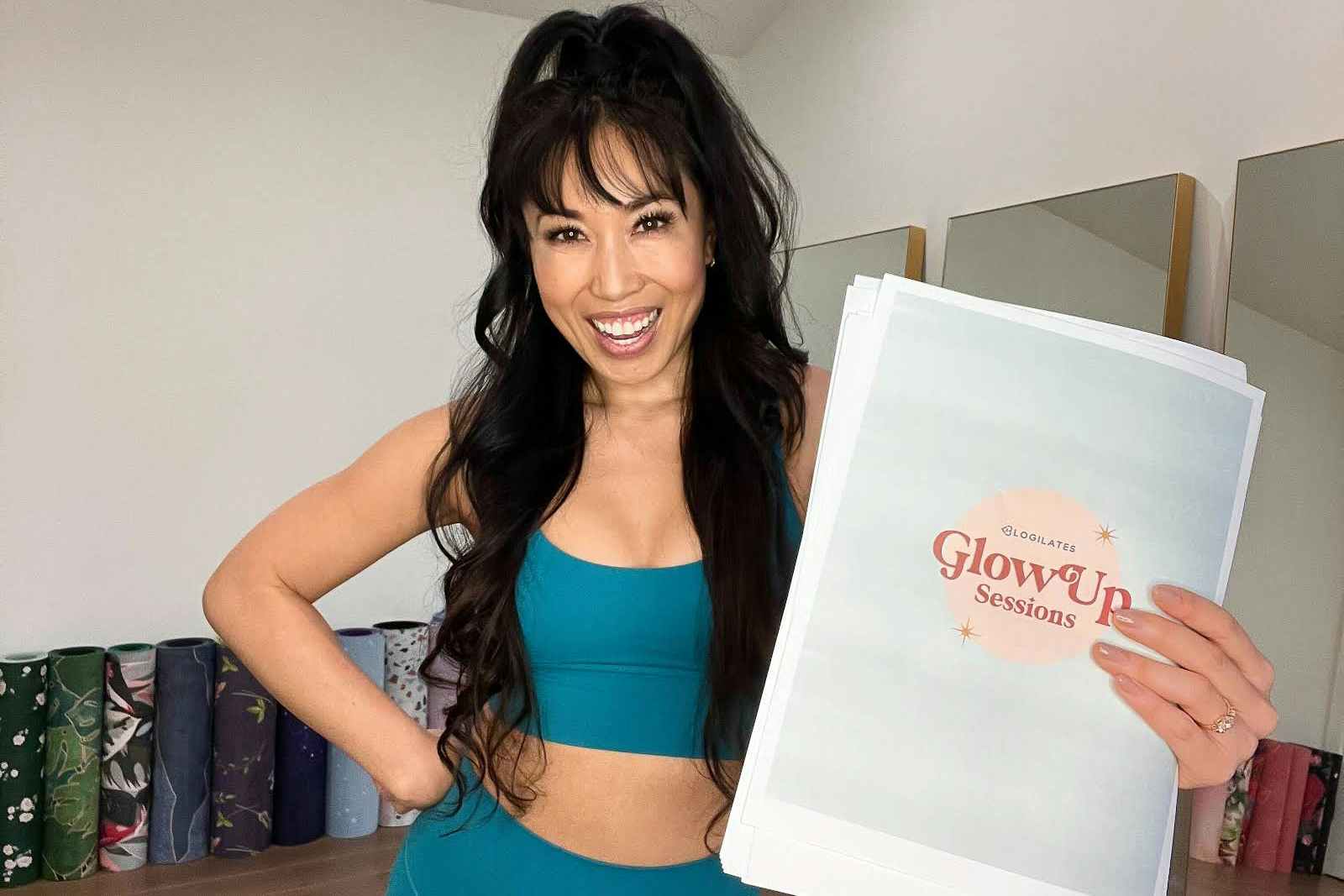 Cassey from the Blogiates Youtube channel holding up a Blogiates Glow Up plan