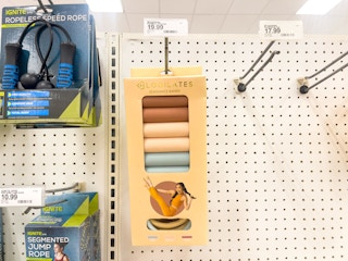 A 3 pack Blogilates resistance bands hanging from a store rack.