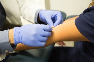 Doctor putting bandage over arm