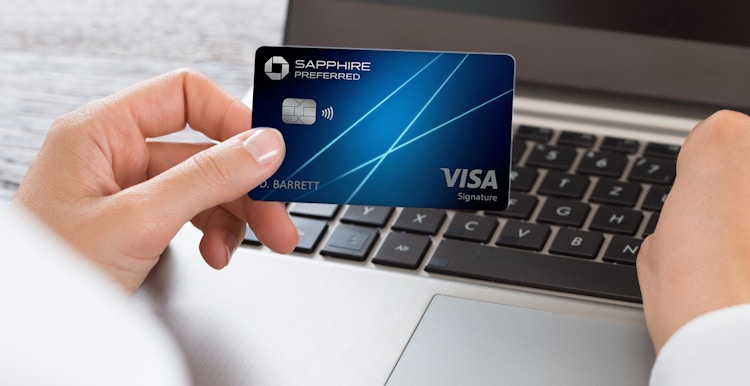 Someone looking at their Chase Sapphire credit card while on their laptop