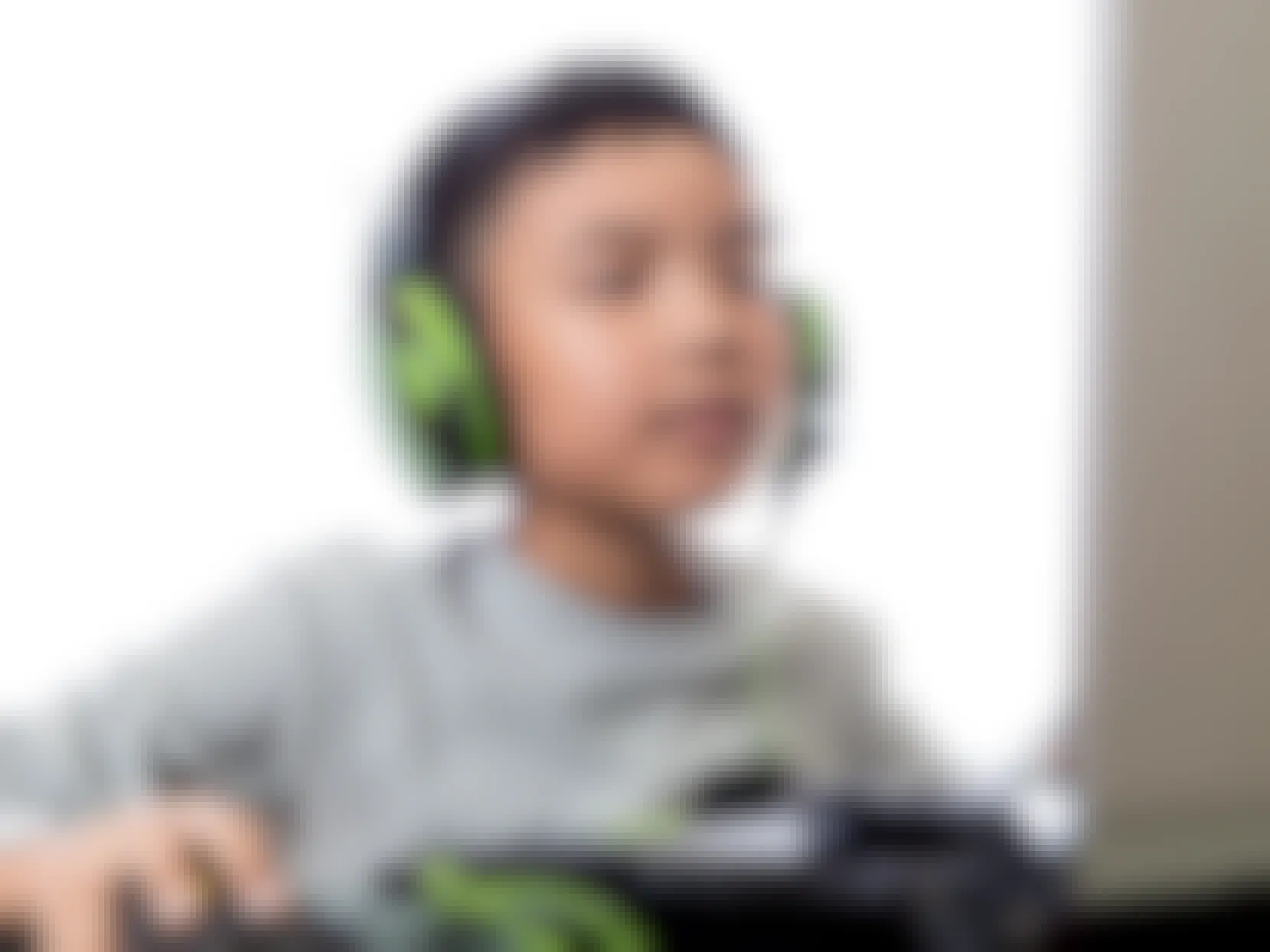 child with headphones working on computer