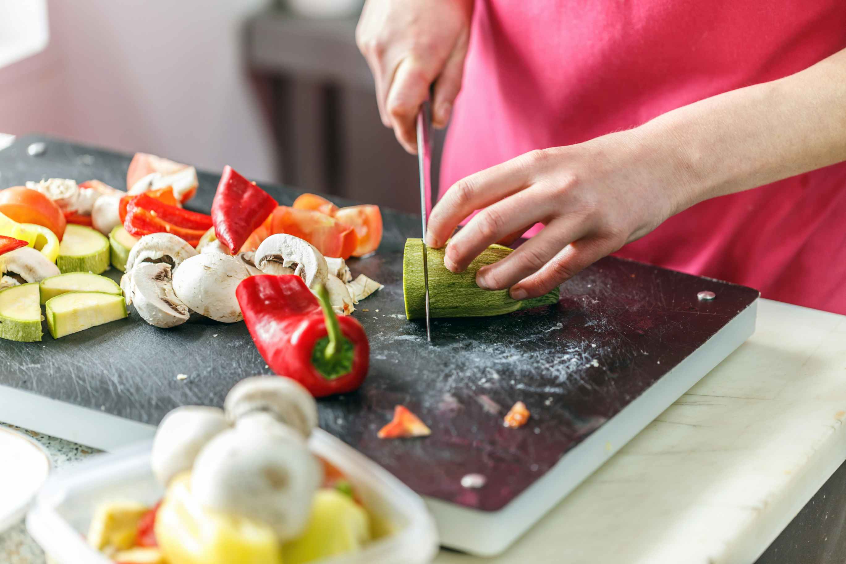 Person chopping up a variety of vegetable on a cutting board