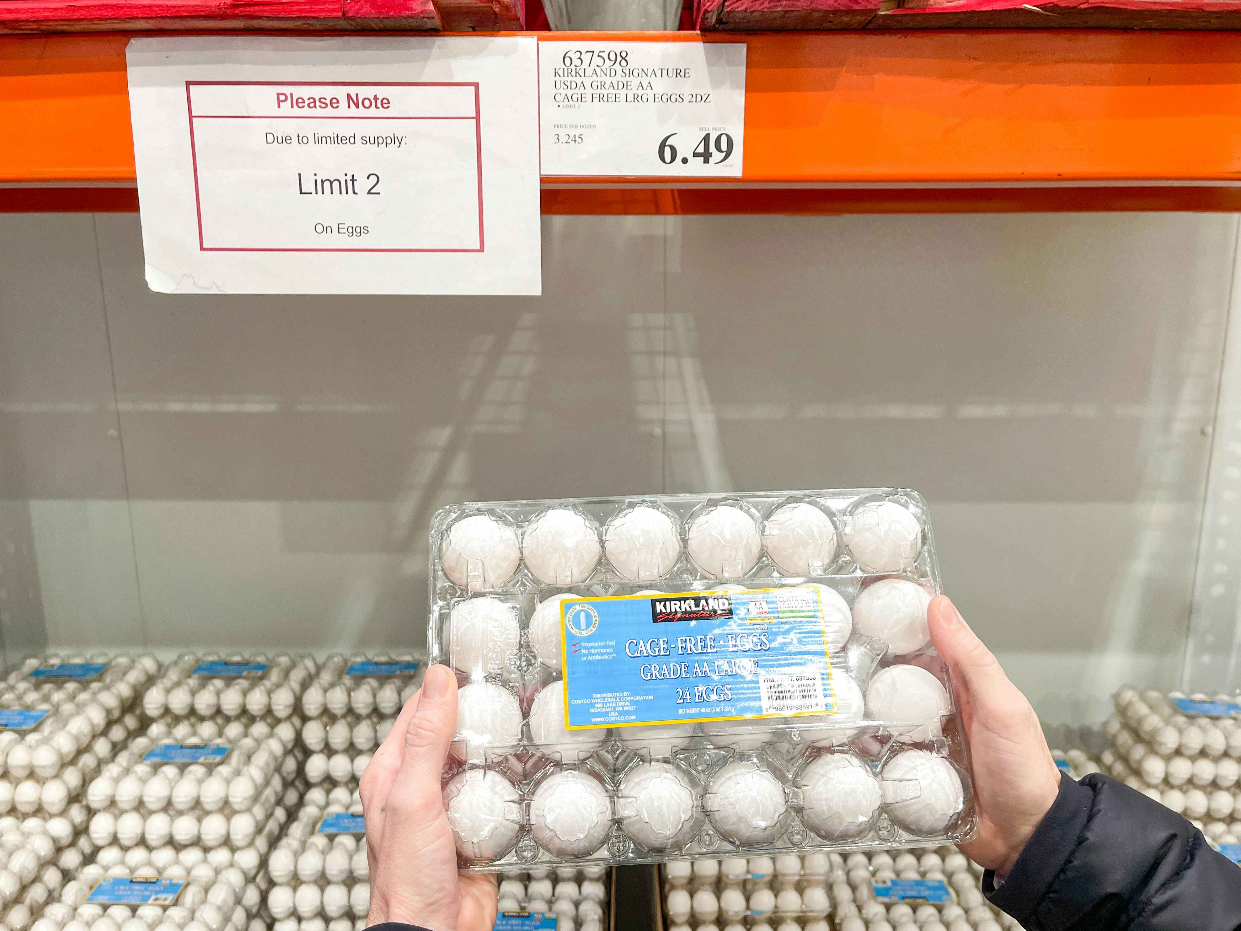 a person holding up eggs in costco 