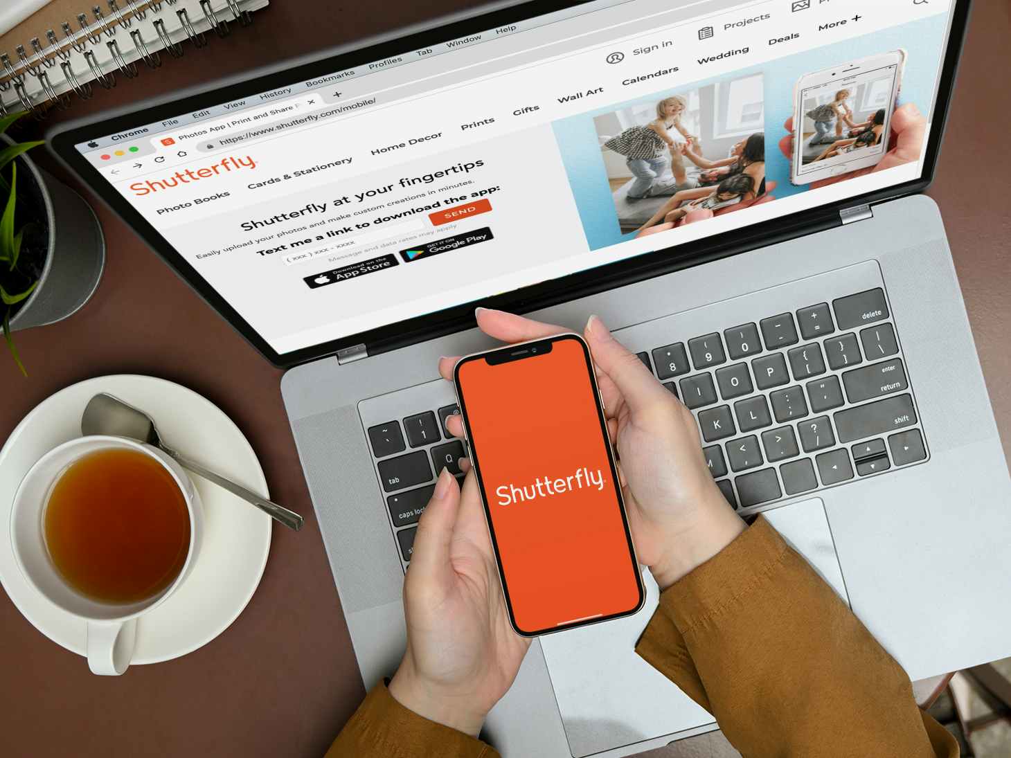 person with laptop and iphone showing shutterfly site and app