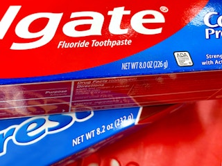 detail of colgate and crest toothpaste boxes with weight