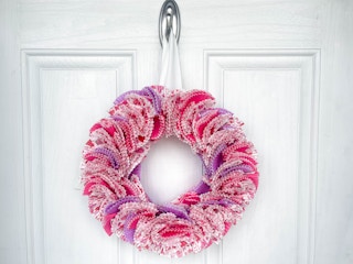 a diy wreath from cupcake liners hanging on a door