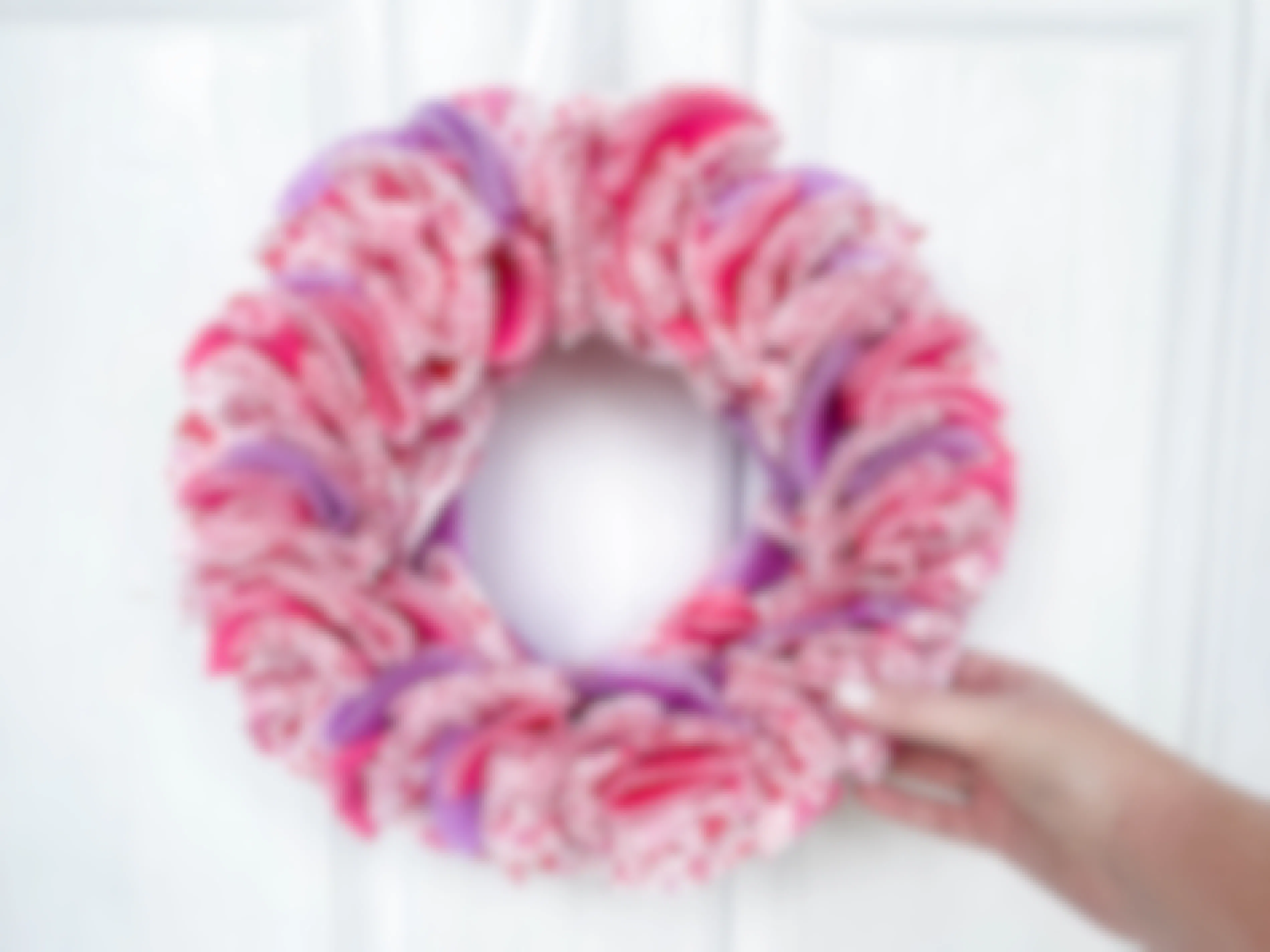 a diy wreath from cupcake liners hanging on a door