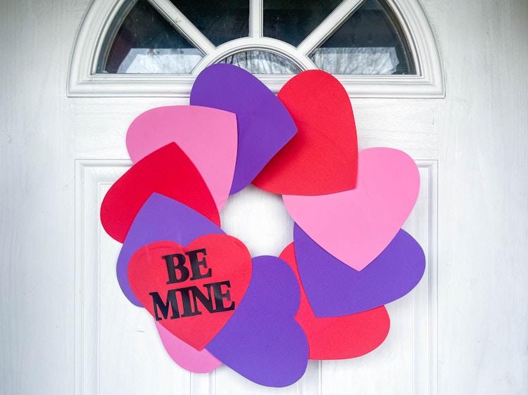 a diy wreath made from foam hearts haging on a door 