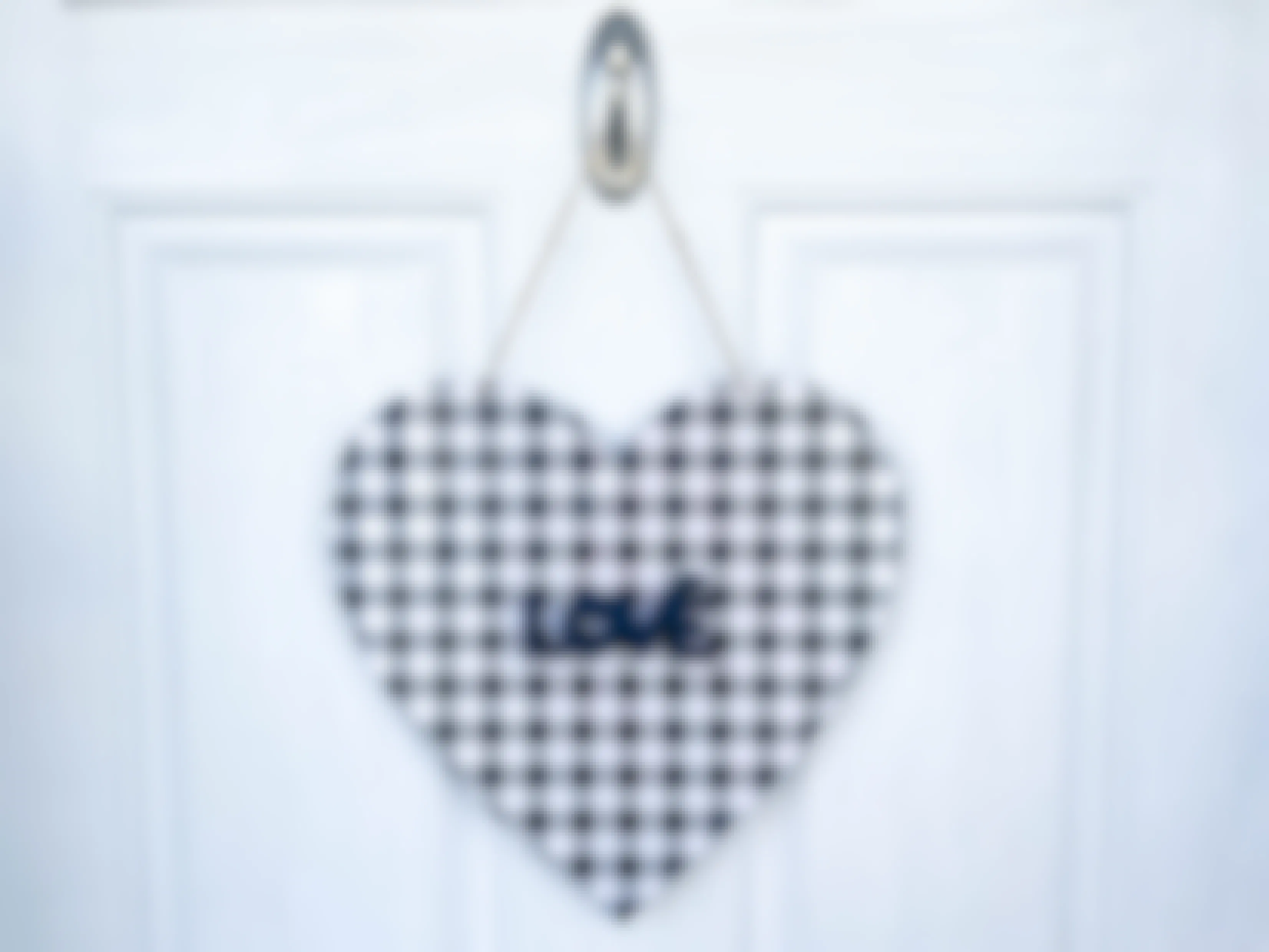 a wood heart covered in vinyl hanging on a door 