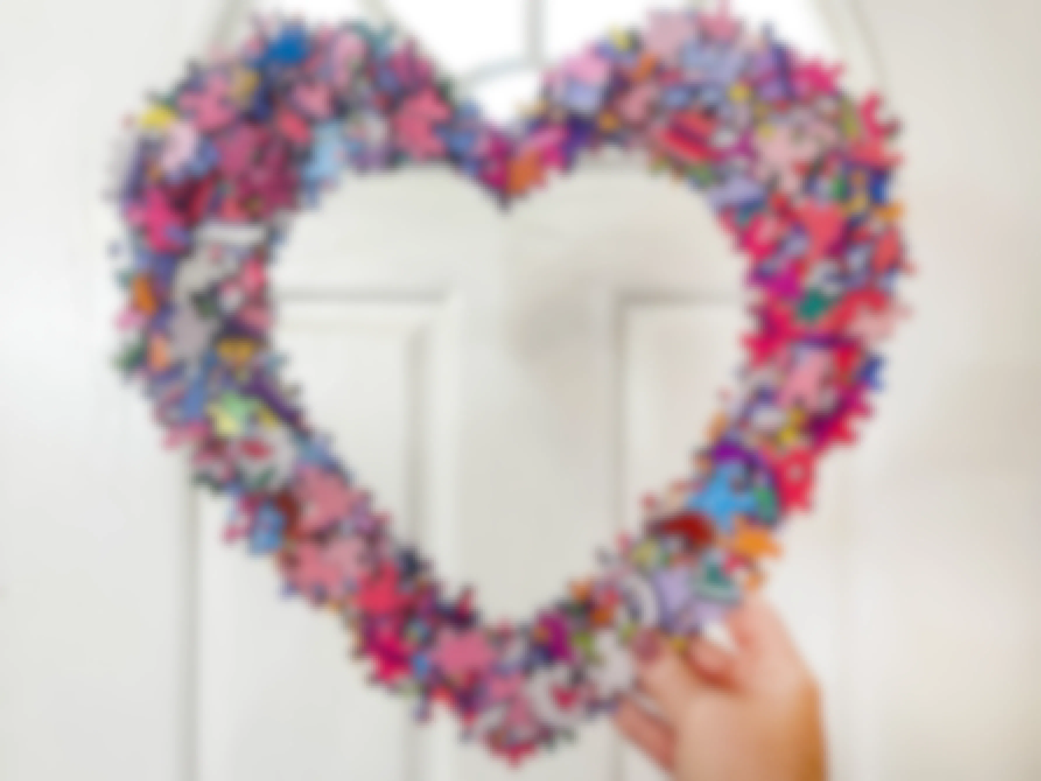 a diy puzzle heart wreath being held