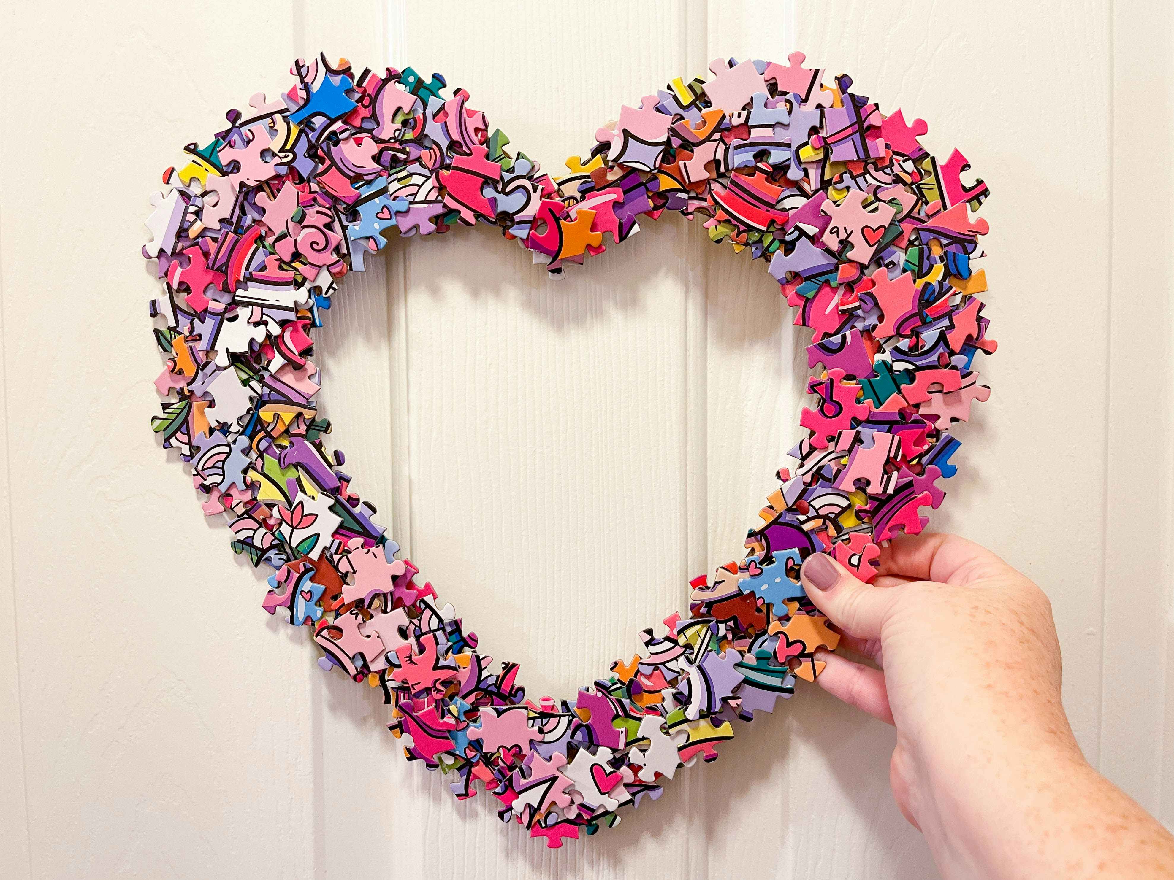 a heart puzzle wreath being held up