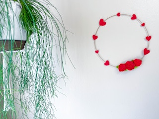 a felt rose and heart wreath hanging on a wall