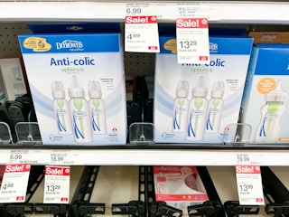 A variety of Dr. Brown Bottles sitting on a store shelf with sale stickers hanging from the rack.