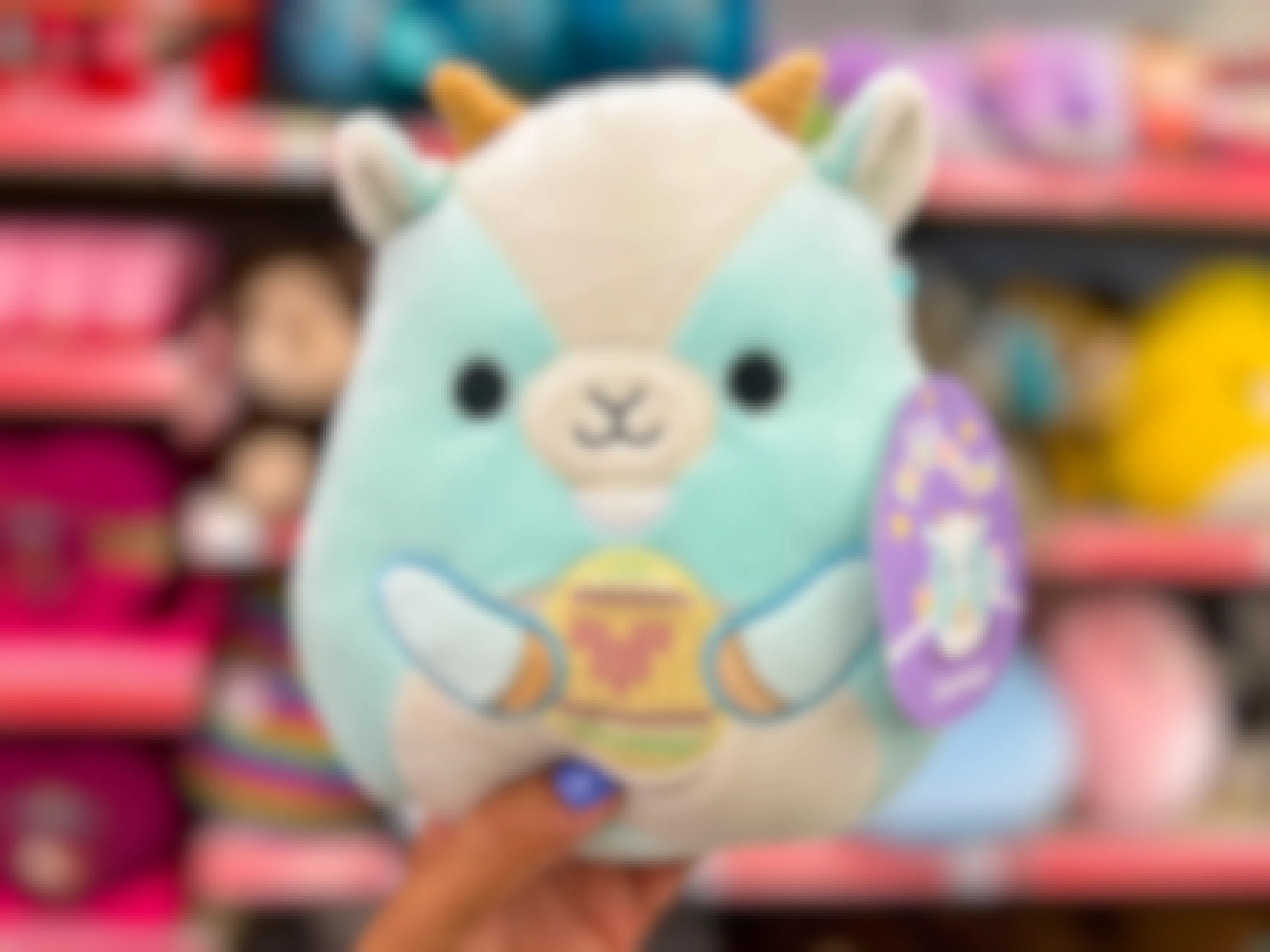 Someone holding up an Easter Domingo Squishmallow in Walgreens