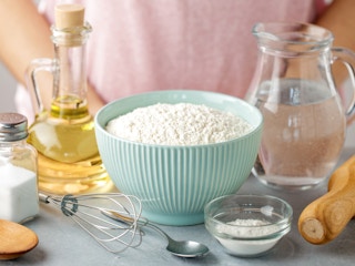 person standing near flour oil water and baking soda