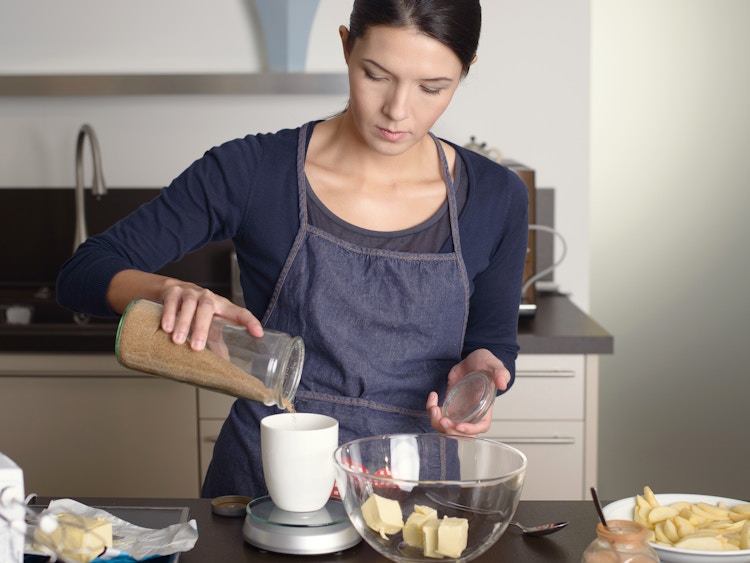person surrounded by ingredients baking in the kitchen